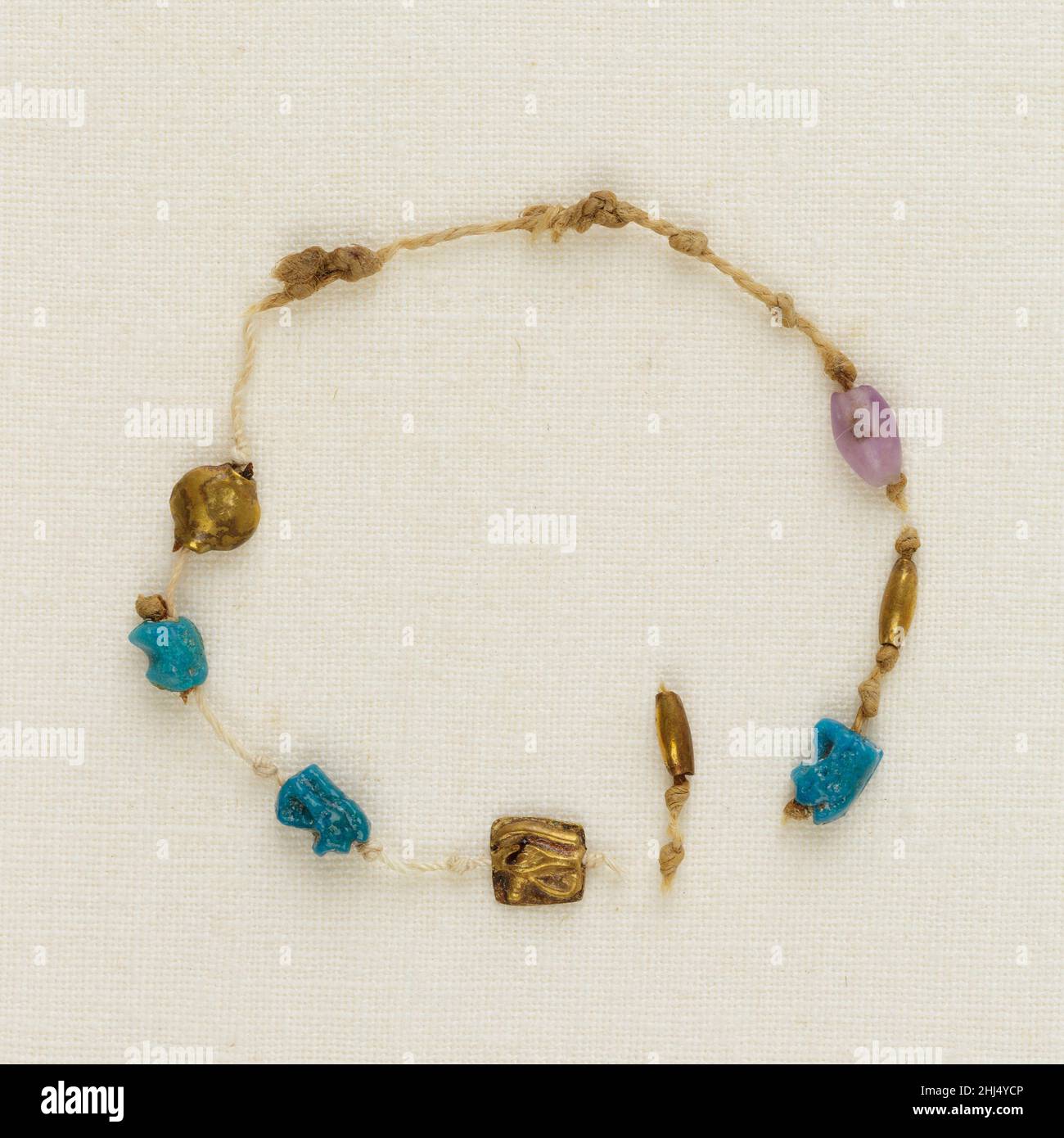 Bracelet avec 4 yeux de wedjat, 2 perles de canon, et 1 perles d'acacia ca.1000–945 C.-B. troisième période intermédiaire un des cinq bracelets trouvés autour du poignet droit de la momie de Henettawy, il s’agit d’une seule rangée de cordon fin.Les quatre amulettes de l'œil de Wedjat, trois de la foi et une d'or, une perle d'or et une perle de canon améthyste, et une perle d'acacia d'or, étaient accrochés à des intervalles le long du fil.Le cordon était cassé, donc l'ordre original des perles et des amulettes est incertain.Les yeux du wedjat représentent l'œil guéri du dieu faucon Horus, un symbole puissant de protection et de régénération.Bracelet avec 4 W Banque D'Images