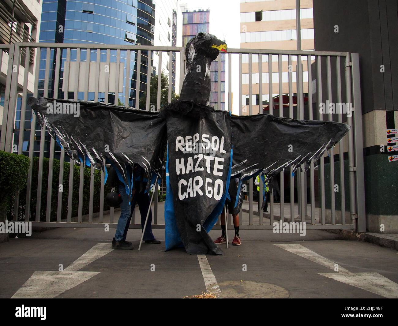 On peut lire « Repsol Take Take Take Take Take charger » sur la poitrine d'un gigantesque oiseau noir suspendu à la porte principale du quartier général de Repsol lorsque des dizaines de manifestants se rassemblent une fois de plus devant les bureaux de Repsol au Pérou pour protester contre la récente marée noire qui a causé une fuite de pétroleCatastrophe écologique sur les côtes de Lima et El Callao.Le 15 janvier, plus de 6 000 000 barils de pétrole ont été déversés dans la mer à la raffinerie de la Pampilla exploitée par Repsol, une compagnie pétrolière espagnole, qui a produit l'une des plus grandes catastrophes écologiques du Pérou. Banque D'Images