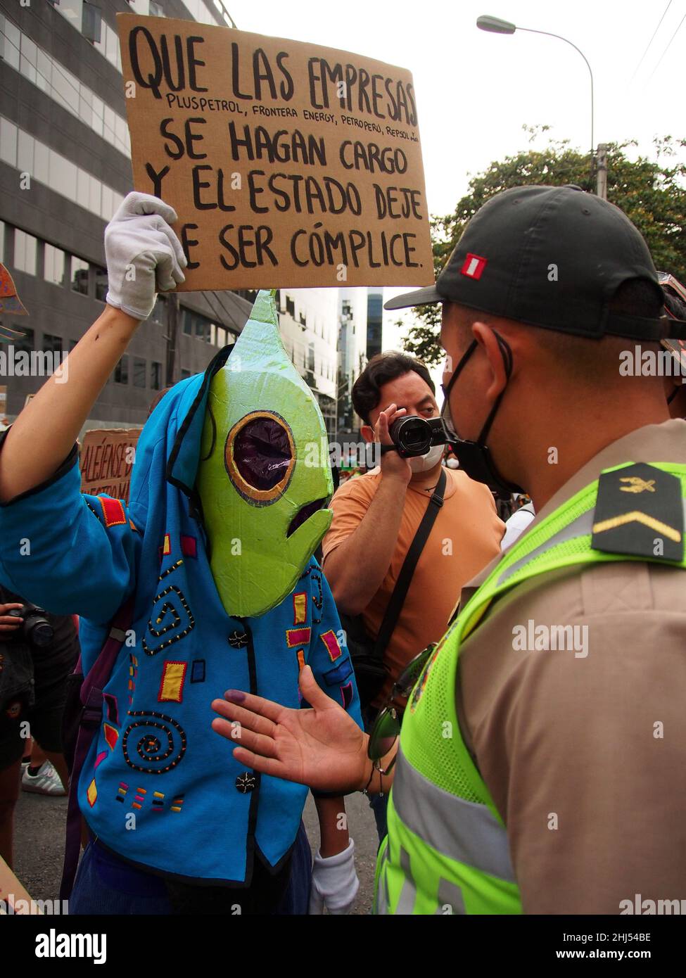 Lima, Pérou.26th janvier 2022.Un démonstrateur à tête de poisson avec une bannière face à la police lorsque des dizaines de manifestants se rassemblent une fois de plus devant les bureaux de Repsol au Pérou pour protester contre la récente marée noire qui a causé une catastrophe écologique sur les côtes de Lima et El Callao.Le 15 janvier, plus de 6 000 000 barils de pétrole ont été déversés dans la mer à la raffinerie de la Pampilla exploitée par Repsol, une compagnie pétrolière espagnole, qui a produit l'une des plus grandes catastrophes écologiques du Pérou.Credit: Agence de presse Fotoholica/Alamy Live News Banque D'Images