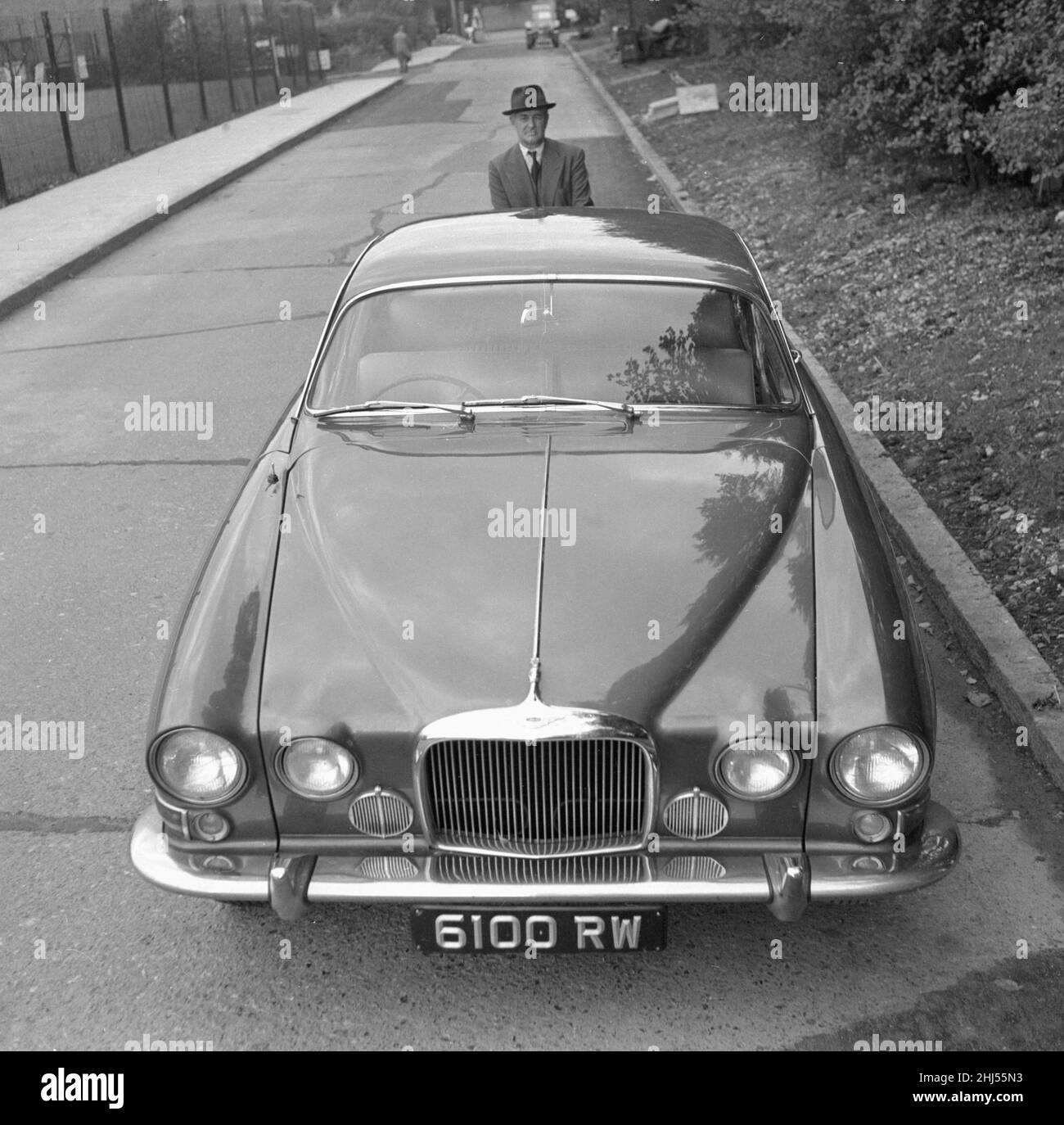 Le correspondant de course automobile du Daily Herald Thomas H Wisdom debout à côté d'une nouvelle Jaguar Mark X. 11th octobre 1961. Banque D'Images