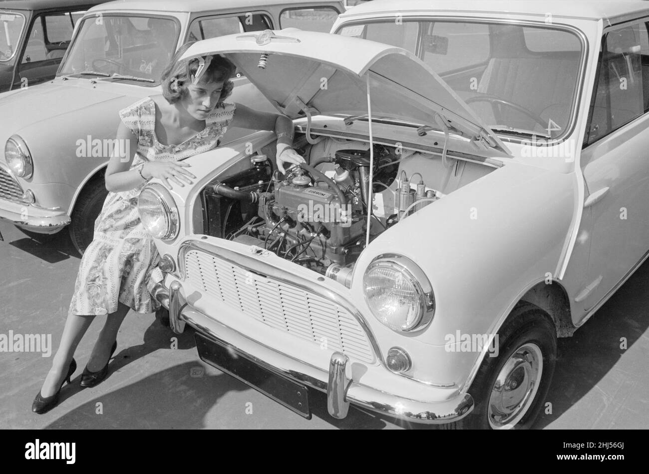 Une femme vérifie le moteur de l'une des premières mini voitures conçues par Alec Issigonis, qui a été lancée par la British Motor Corporation en 1959.20th août 1959. Banque D'Images