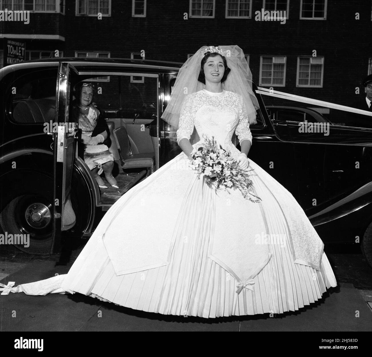 Yvonne Napier arrive pour son mariage à Arnold Phelps à Londres.La robe de  la mariée, conçue par David Garrat, a été faite de satin de poult avec  corsage de dentelle et panneaux.Il