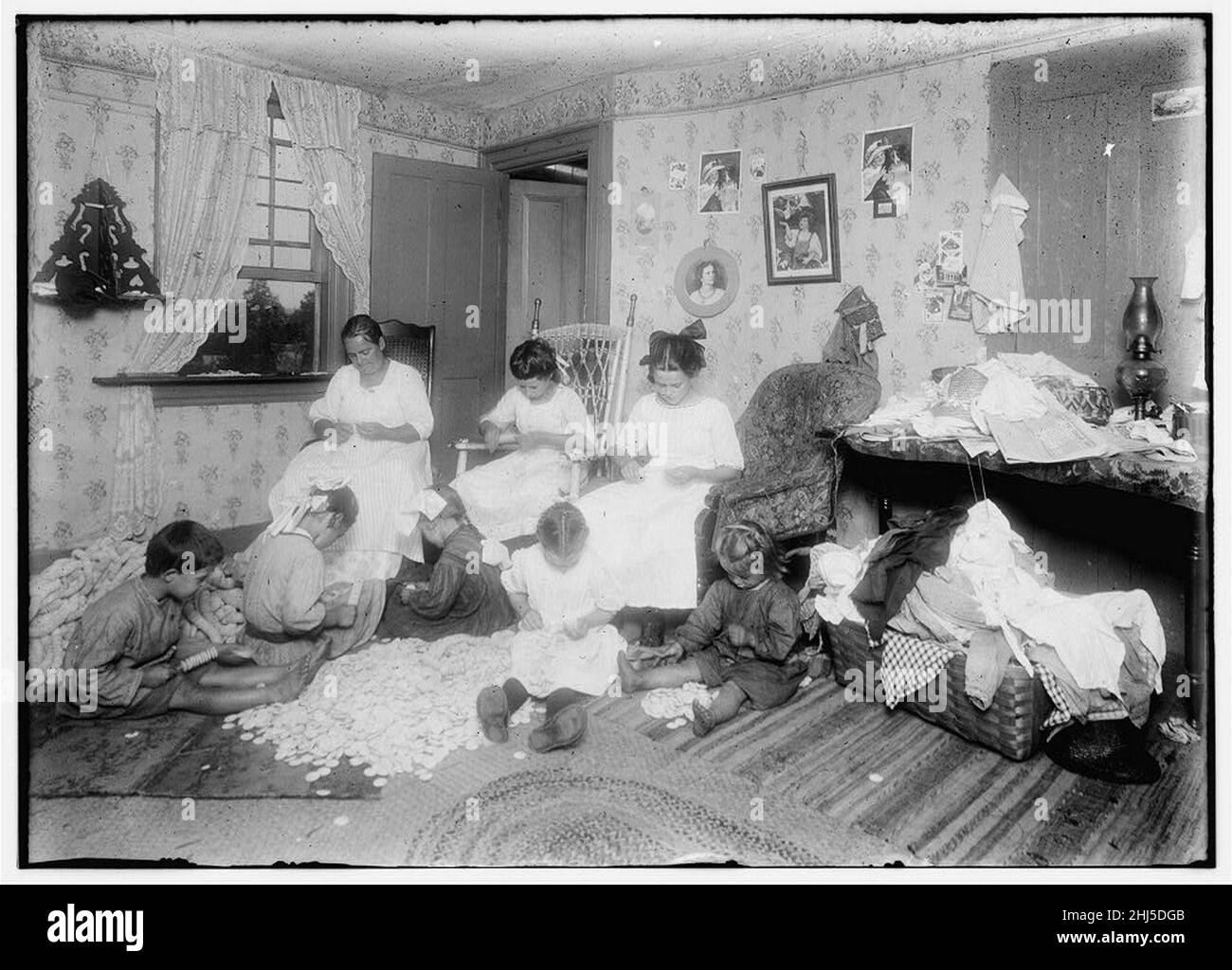 Boutons en bois (moules à boutons) dans une maison surpeuplée, Williamsburg, Massachusetts Mme Weeks et ses enfants 13 ans, 11 ans, 7 ans et ses grands enfants 7 ans, 5 ans et 4 ans Banque D'Images