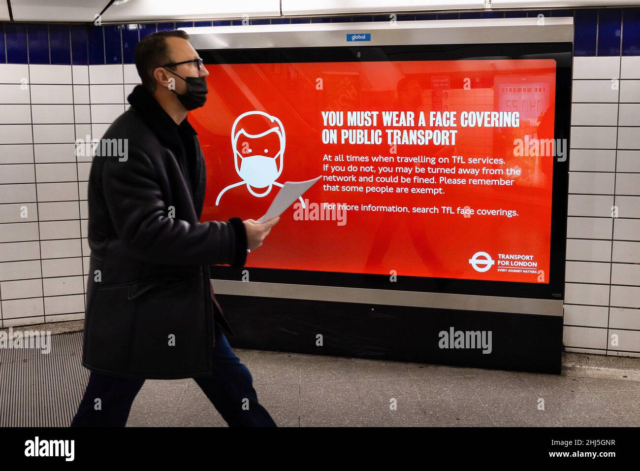 Londres, Royaume-Uni.26th janvier 2022.Un homme portant un masque marche devant un panneau qui remette les navetteurs de porter un visage couvrant les transports en commun à la station Leicester Square de Londres.À partir du 27th janvier, l'utilisation du masque facial dans tous les lieux publics cessera d'être obligatoire car la menace posée par la variante Omicron des sous-camps Covid-19.(Photo de Tejas Sandhu/SOPA Images/Sipa USA) Credit: SIPA USA/Alay Live News Banque D'Images