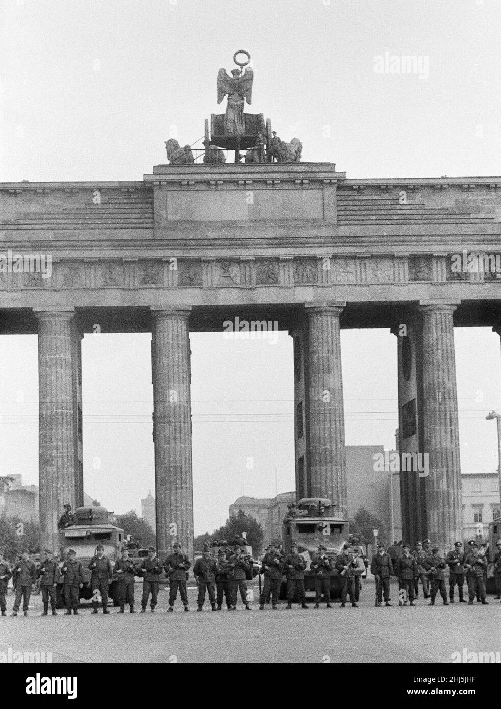 Début de la construction du mur de Berlin.Le 13th août à minuit, la police et les unités de l'armée est-allemande ont commencé à fermer la frontière et, le dimanche matin 13 août, la frontière avec Berlin-Ouest a été fermée.La photo prise trois jours après montre: Les camarades des groupes de combat de la classe de travail, employés pour protéger la frontière, se tiennent prêts à la porte de Brandebourg, protégé par un véhicule blindé scout de la police des frontières.Le site est visité par le maire de Berlin-Ouest Willy Brandt et les généraux de l'armée américaine.16th août 1961. Banque D'Images