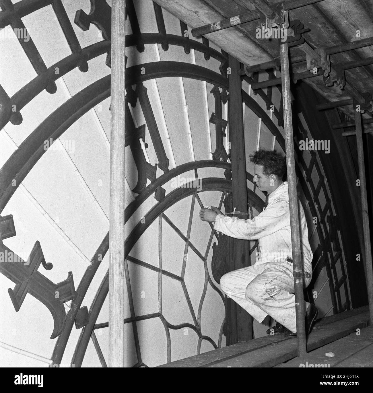 Un ouvrier inspecte la petite main de la face de l'horloge de Big Ben lors de la révision majeure de toutes les cloches et du mécanisme de l'horloge dans la tour de la reine Elizabeth.Alors que Big Ben a été réduit au silence pendant la révision de Big Tom, la cloche de la cathédrale Saint-Paul était restée pour les carillons de la BBC.Londres, le 23rd août 1956 Banque D'Images