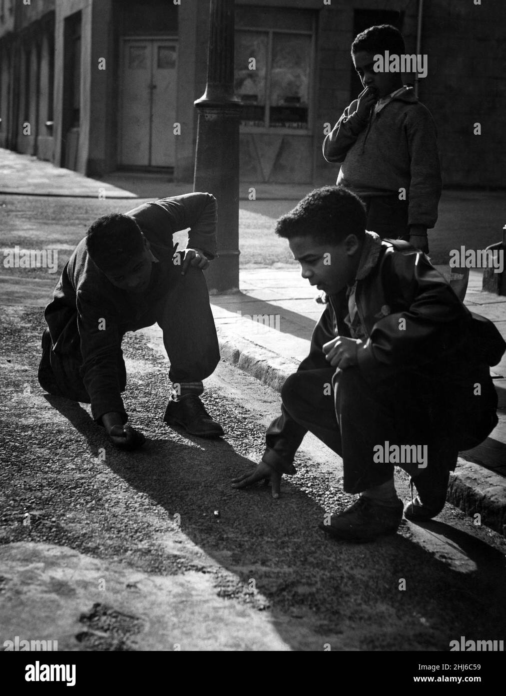 Garçons jouant des marbres à Butetown, Cardiff.22nd mars 1957. Banque D'Images