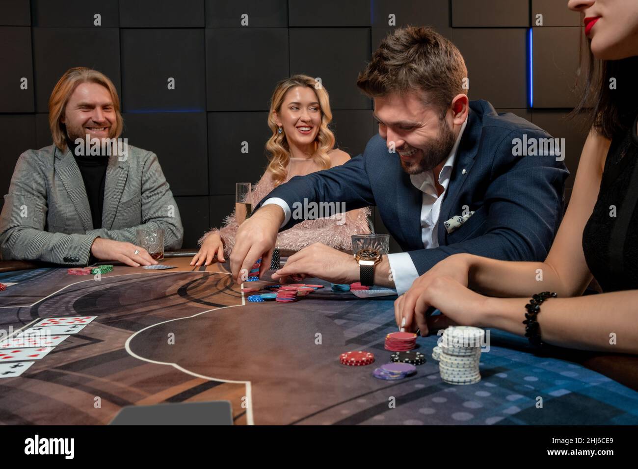 Joyeux barbu gars assis à la table de poker dans le casino et faisant le pari Banque D'Images