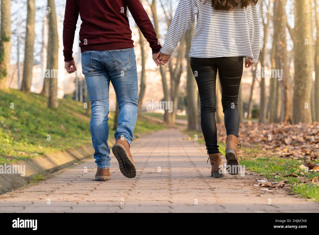 Jeune couple hétérosexuel marchant et s'embrassant dans un parc le jour de la Saint-Valentin Banque D'Images