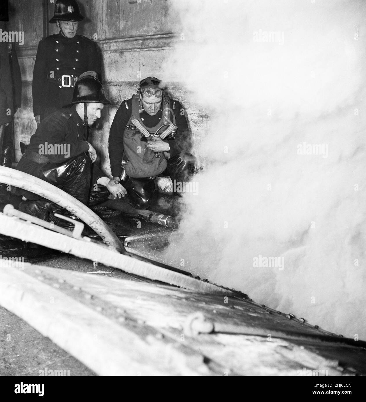 Scènes au marché de la viande de Smithfield dans le centre de Londres après qu'un incendie a éclaté dans les locaux de Union Cold Storage Co. Le feu, assisté par la brigade des pompiers de Londres, a brûlé pendant trois jours dans le labryinthe vieux de plusieurs siècles avant qu'il ne s'effondre.Photo prise : 23rd janvier 1958. Banque D'Images
