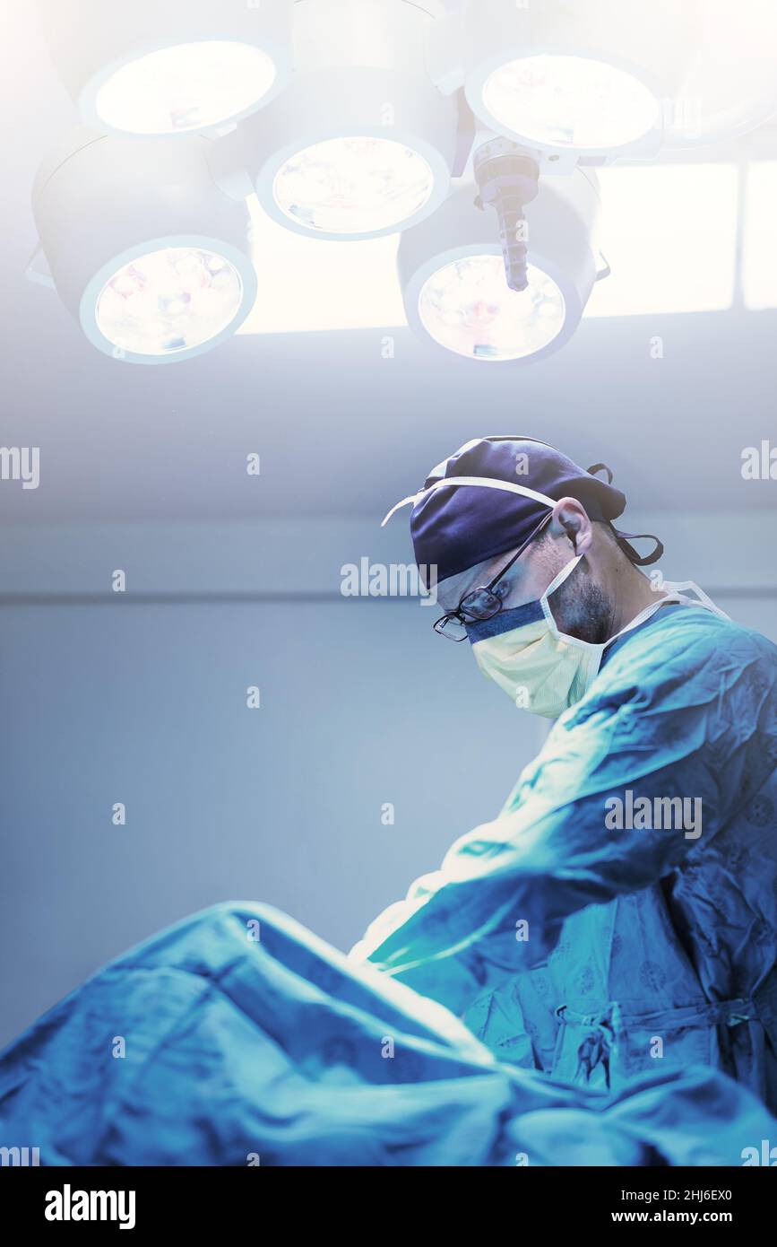 Chaque chirurgie obtient son attention indivise.Photo d'un jeune chirurgien spécialisé effectuant une chirurgie sur un patient dans une salle d'opération. Banque D'Images