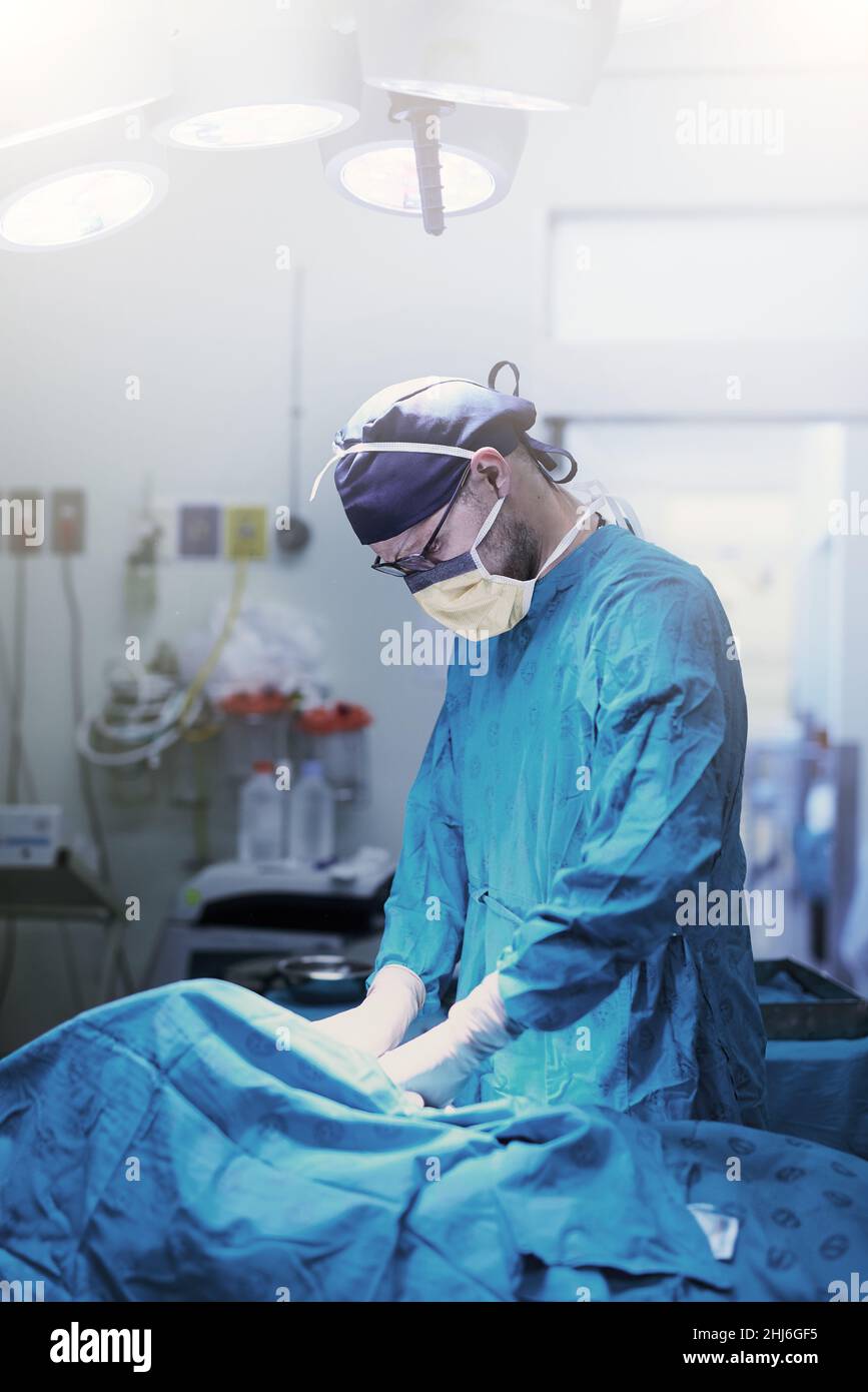 Où la vie est toujours au centre.Photo d'un jeune chirurgien spécialisé effectuant une chirurgie sur un patient dans une salle d'opération. Banque D'Images