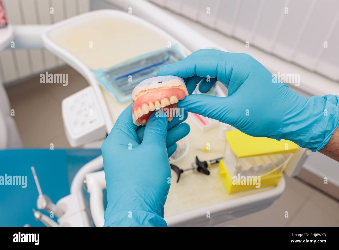 Prothèse dentaire dans les mains du médecin en gros plan.Dentiste tenant un pont dentaire en céramique.Vue avant de la prothèse complète.Dentisterie conceptuelle Banque D'Images