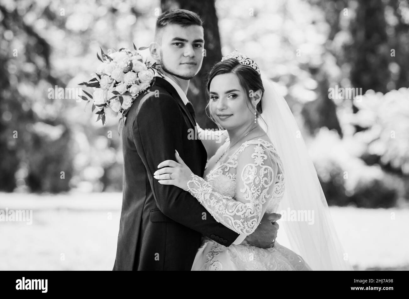 La mariée et le marié marchent dans le parc en été, embrassant.Les