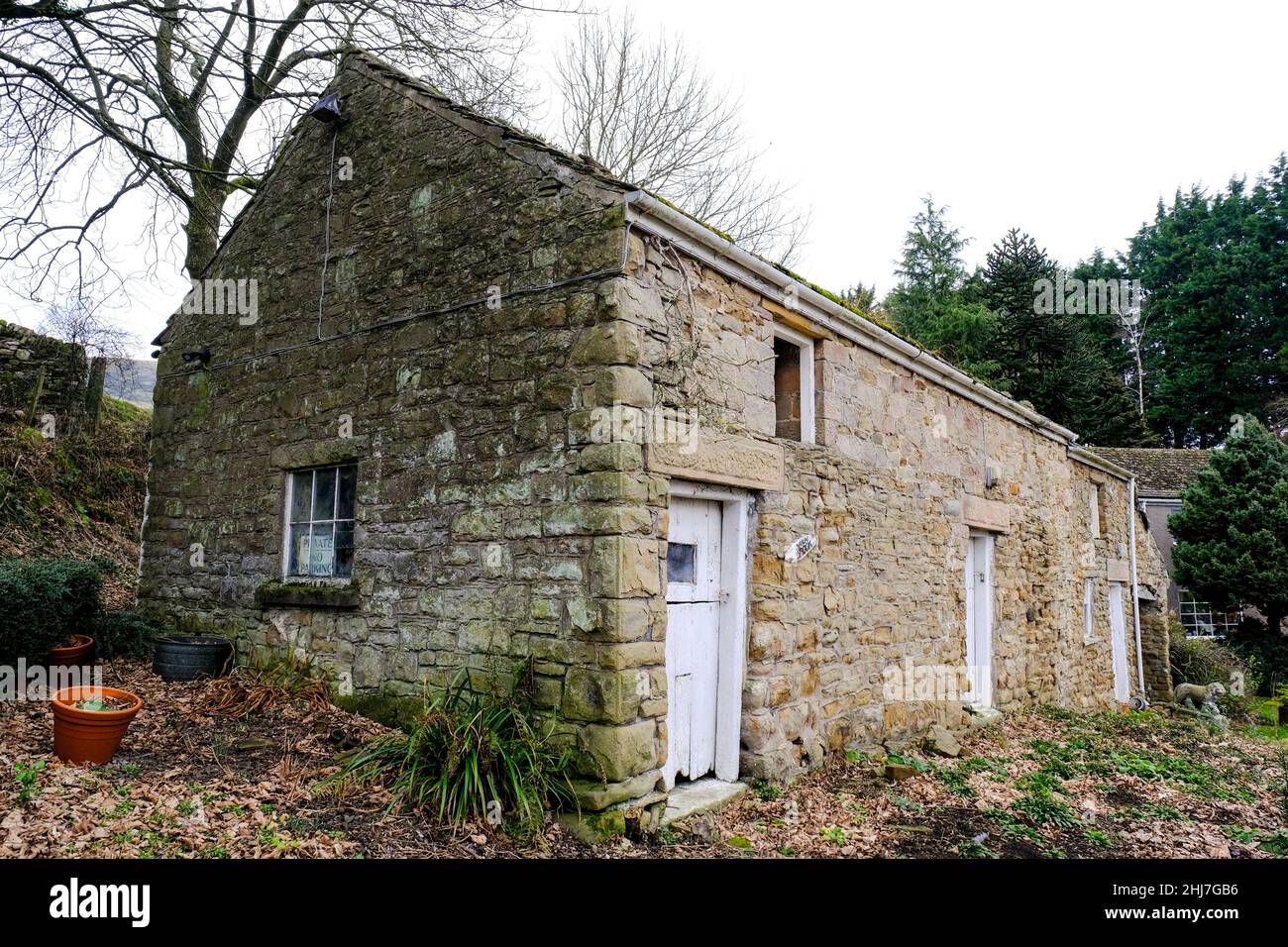 Une ancienne grange en pierre près d'Aston, Derbyshire avec des portes en bois peintes en blanc dans un état de déréparation. Banque D'Images Une ancienne grange en pierre près d'Aston, Derbyshire avec des portes en bois peintes en blanc dans un état de déréparation. Banque D'Images
