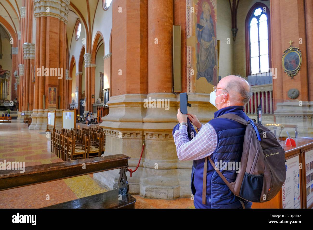 Bologne, Italie: Homme aîné portant un masque médical et faisant la photo avec un smartphone dans la basilique de San Petronio sur la place, P Banque D'Images