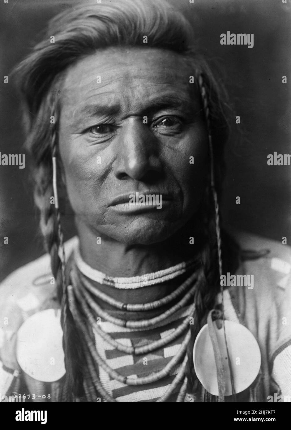 Portrait de Crow man - photo ancienne et vintage - amérindien / Indien / Indien américain. Curtis, Edward S., 1868-1952, photographe, 1908. Banque D'Images Portrait de Crow man - photo ancienne et vintage - amérindien / Indien / Indien américain. Curtis, Edward S., 1868-1952, photographe, 1908. Banque D'Images