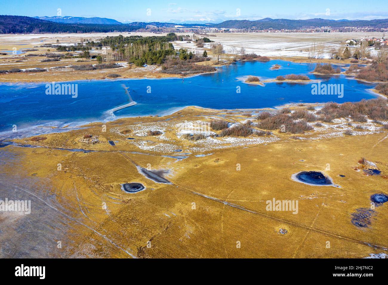 Vue aérienne des personnes qui patinent sur le lac gelé intermittent Cerknica, prise par drone, Slovénie Banque D'Images