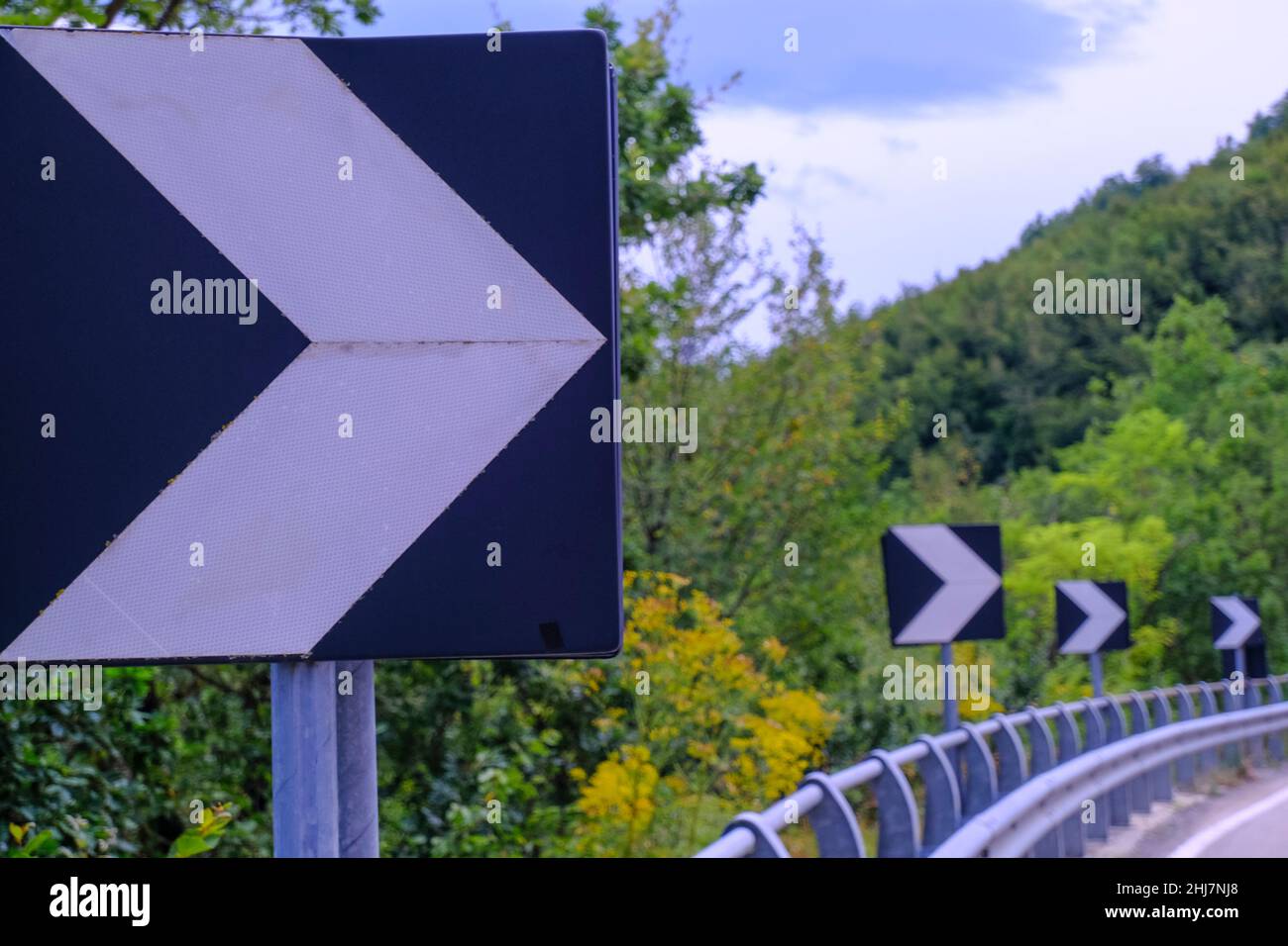 flèches de signalisation routière sur une route de près sur la route sinueuse dans les montagnes à travers les bois.Le concept de tournage, de torsion, de changements Banque D'Images