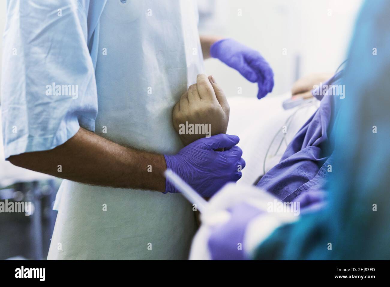 Vous êtes maintenant entre des mains sûres.Prise de vue rognée d'un médecin tenant un patient par son poignet au cours d'une intervention médicale. Banque D'Images