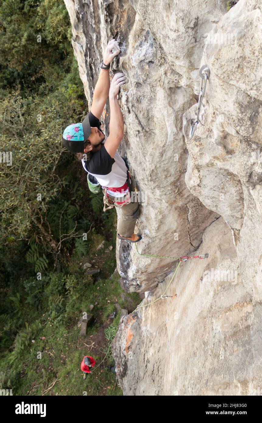 Le grimpeur de roche hispanique s'est concentré sur l'escalade d'une magnifique falaise texturée Banque D'Images