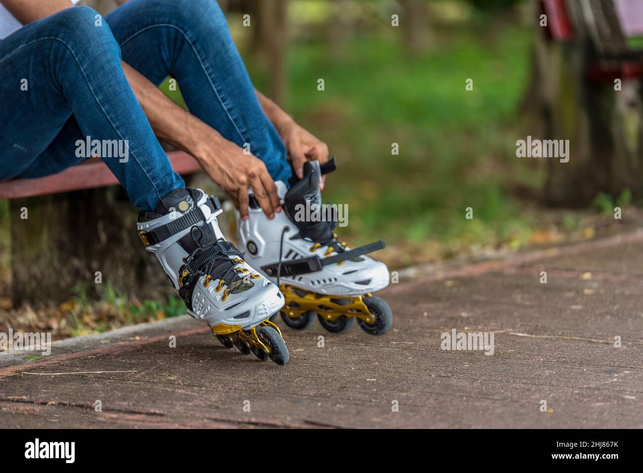 Close-up of young man putting on inline skates Banque D'Images