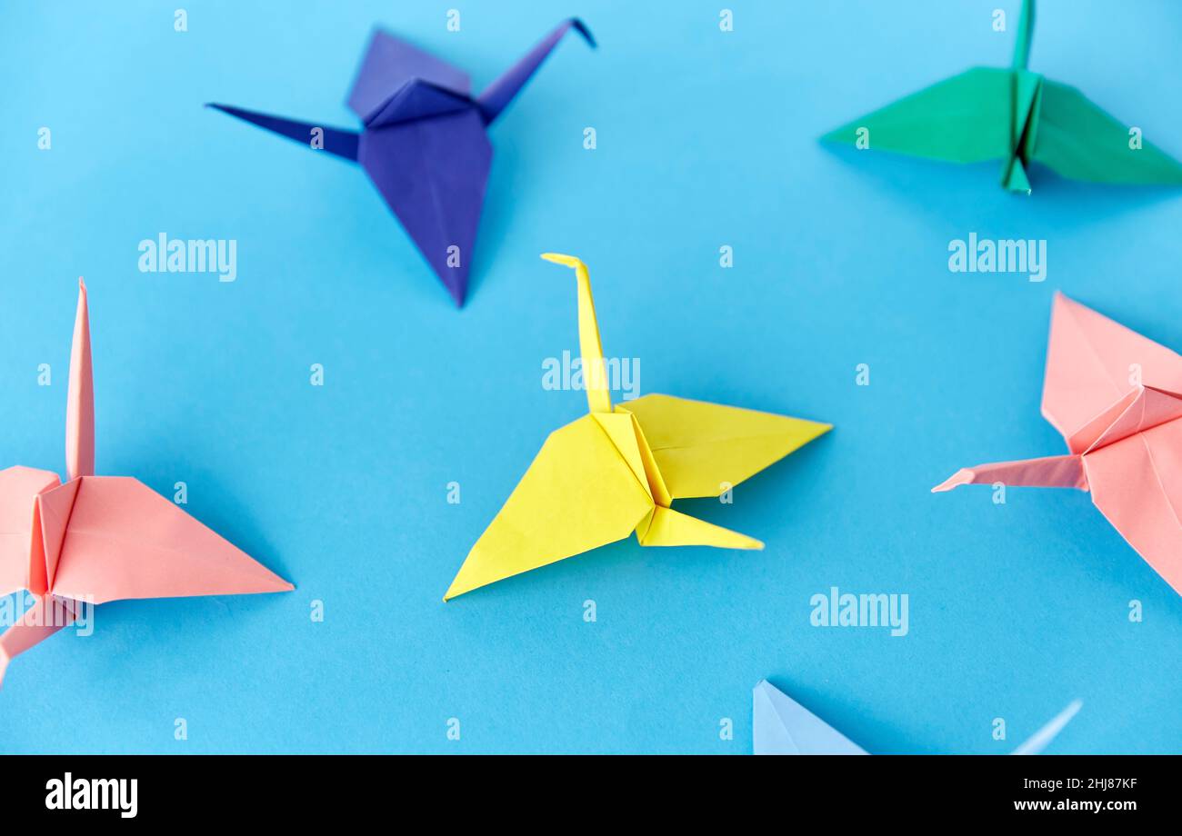grues en papier origami sur fond bleu Banque D'Images