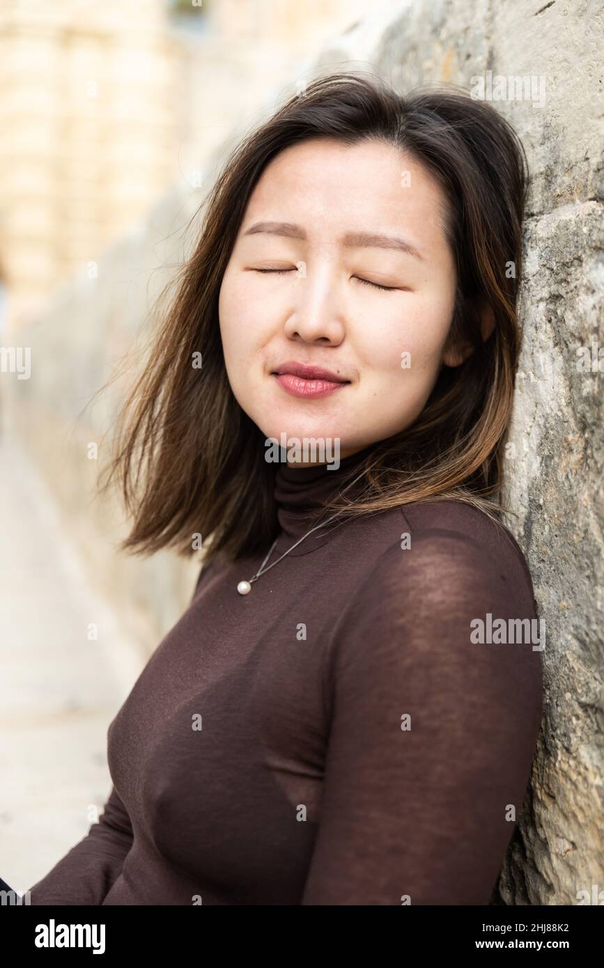 Portrait d'une jolie fille asiatique américaine de 29 ans, les yeux debout fermés Banque D'Images