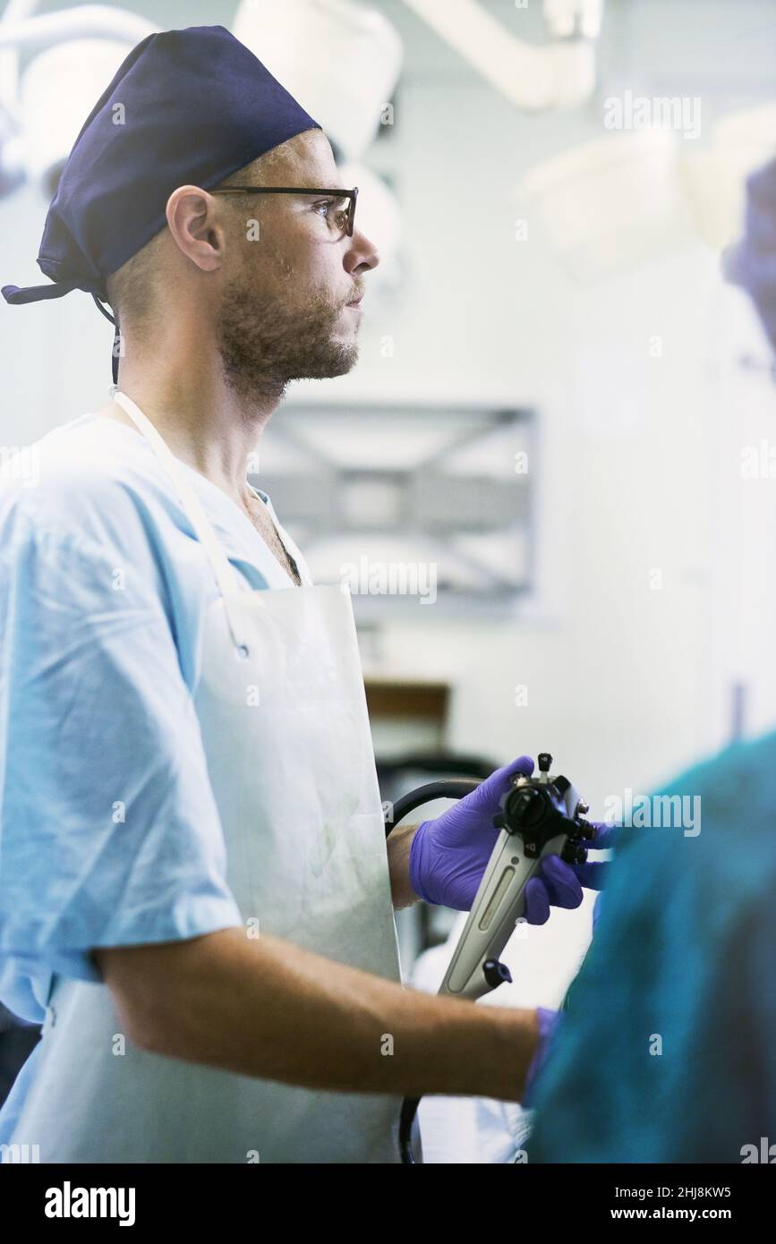 L'accent est mis sur la sauvegarde de vies.Cliché d'un jeune chirurgien effectuant une chirurgie sur un patient dans une salle d'opération. Banque D'Images
