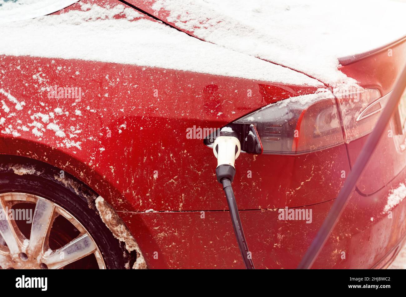 Une voiture électrique est chargée à partir d'une station de charge électrique en hiver.Transport écologique.Transport sur batteries Banque D'Images