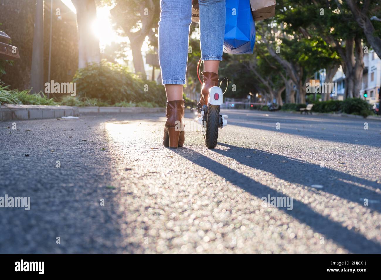 femme sur le scooter électrique transportant des sacs en papier Banque D'Images