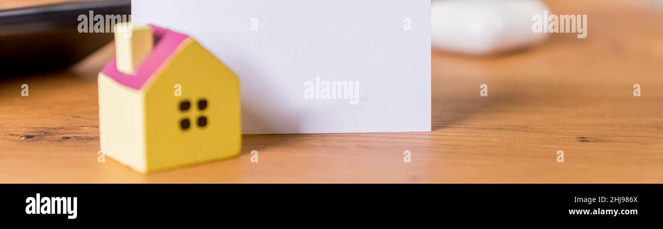 Porte-clés et porte-clés en forme de maison sur fond bleu. Banque D'Images