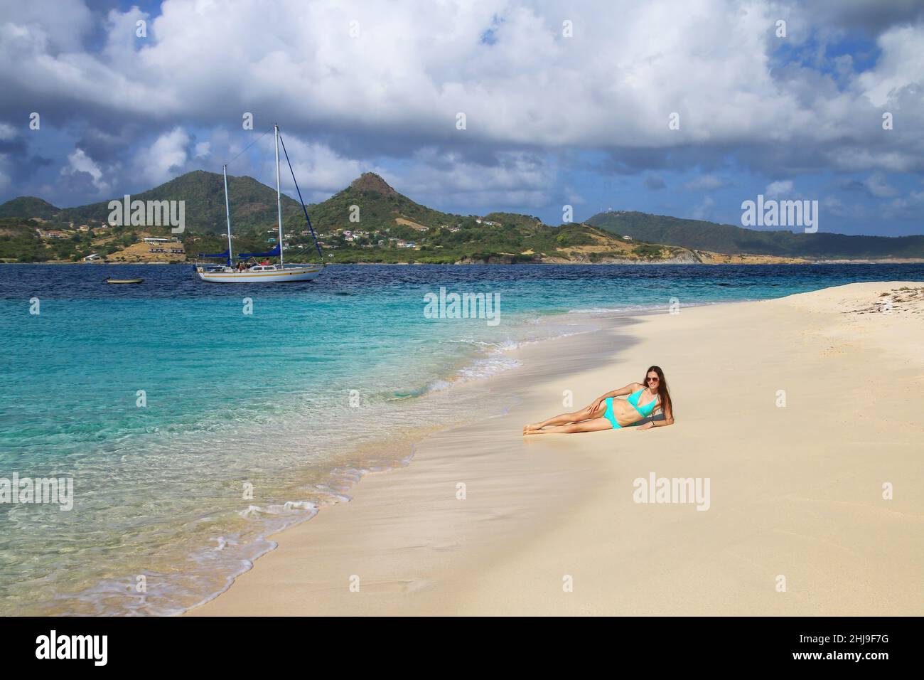 Jeune femme en bikini se relaxant à la plage, White Island, Grenade. Banque D'Images