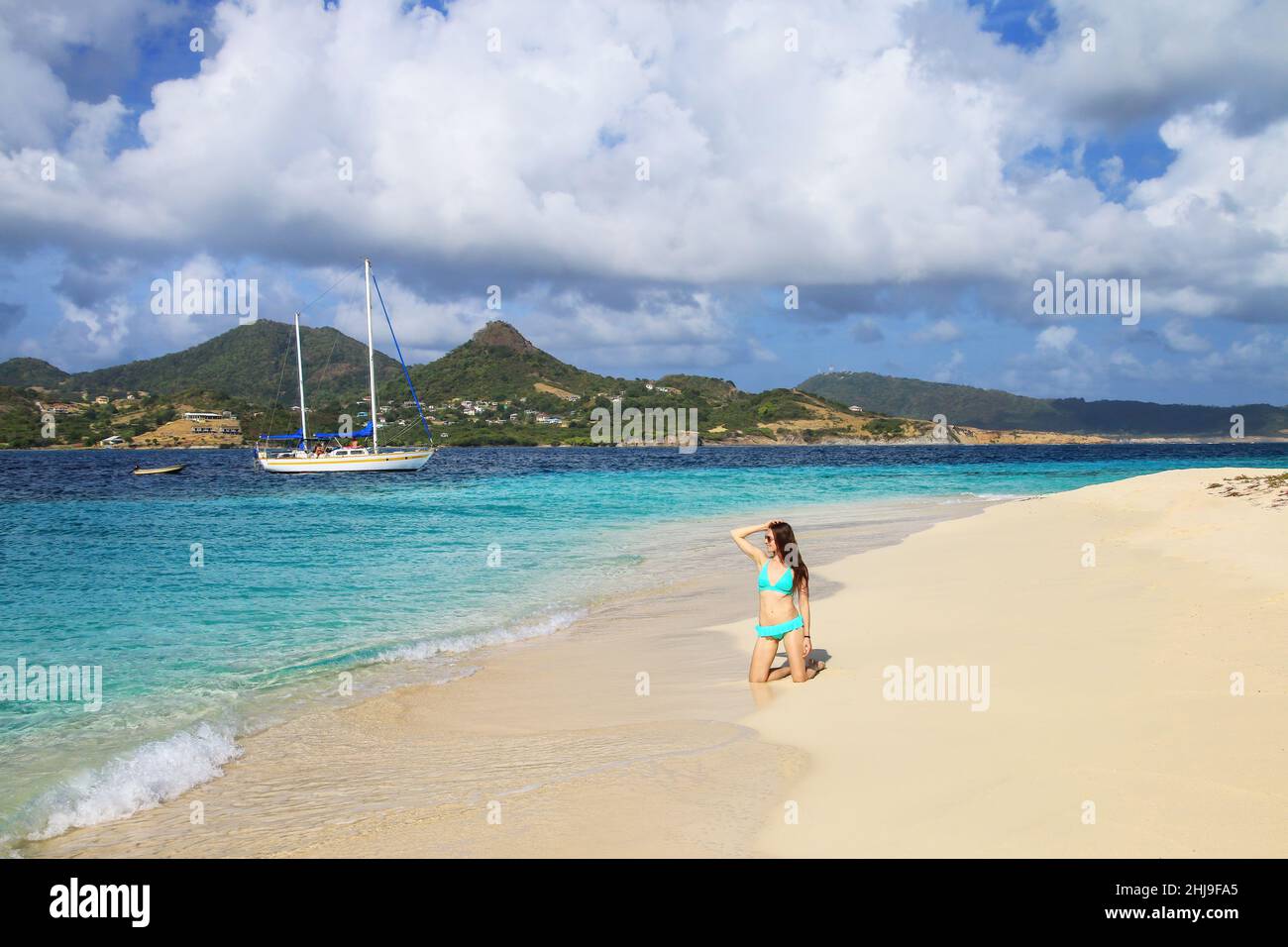 Jeune femme en bikini se relaxant à la plage, White Island, Grenade. Banque D'Images