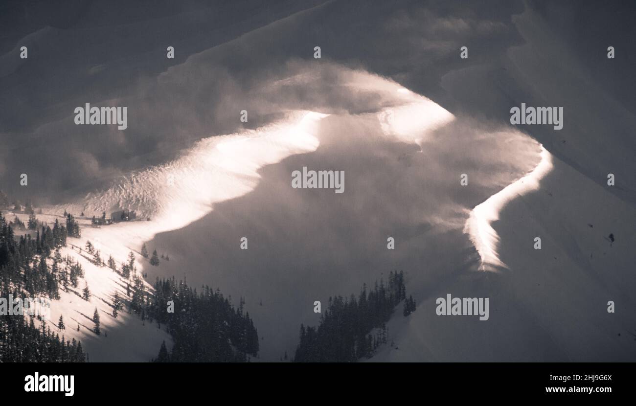 Rayons ensoleillés d'une journée d'hiver sur les pentes d'une montagne volcanique couverte de neige et de pins Banque D'Images