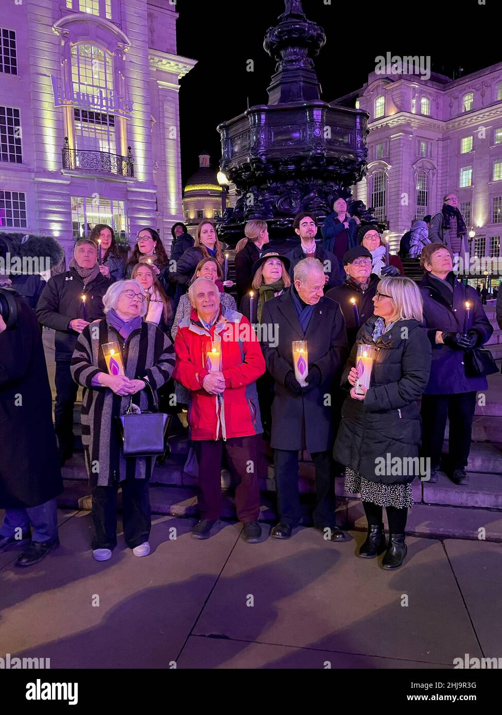 Les survivants de l'Holocauste se sont réunis à Piccadilly Circus, dans le centre de Londres, pour allumer des bougies et se souvenir des victimes du génocide lors du jour commémoratif de l'Holocauste, les bâtiments environnants étant éclairés en violet.Date de la photo: Jeudi 27 janvier 2022. Banque D'Images