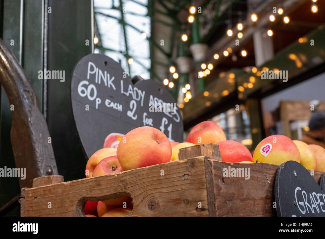 Borough Market, marché urbain couvert à Southwark, dans l'est de Londres, avec une large gamme d'étals alimentaires.Caisse en bois avec pommes Pink Lady au premier plan Banque D'Images