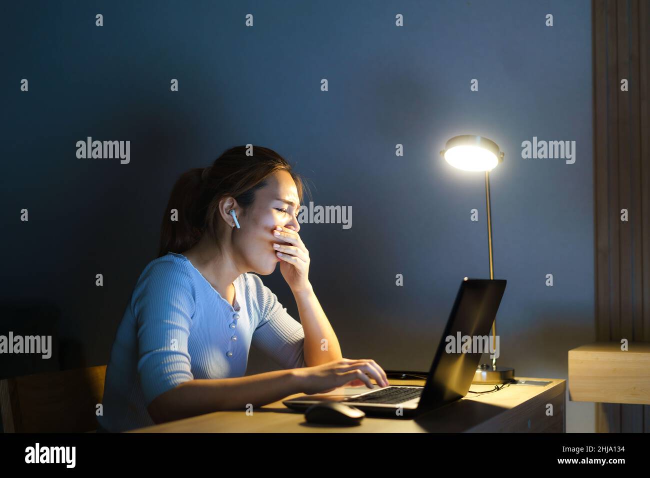 Femme d'affaires asiatique travaillant sur son ordinateur portable pour préparer la présentation demain matin le soir, elle avait l'air si somnolent et fatiguée qu'elle a hurlée Banque D'Images