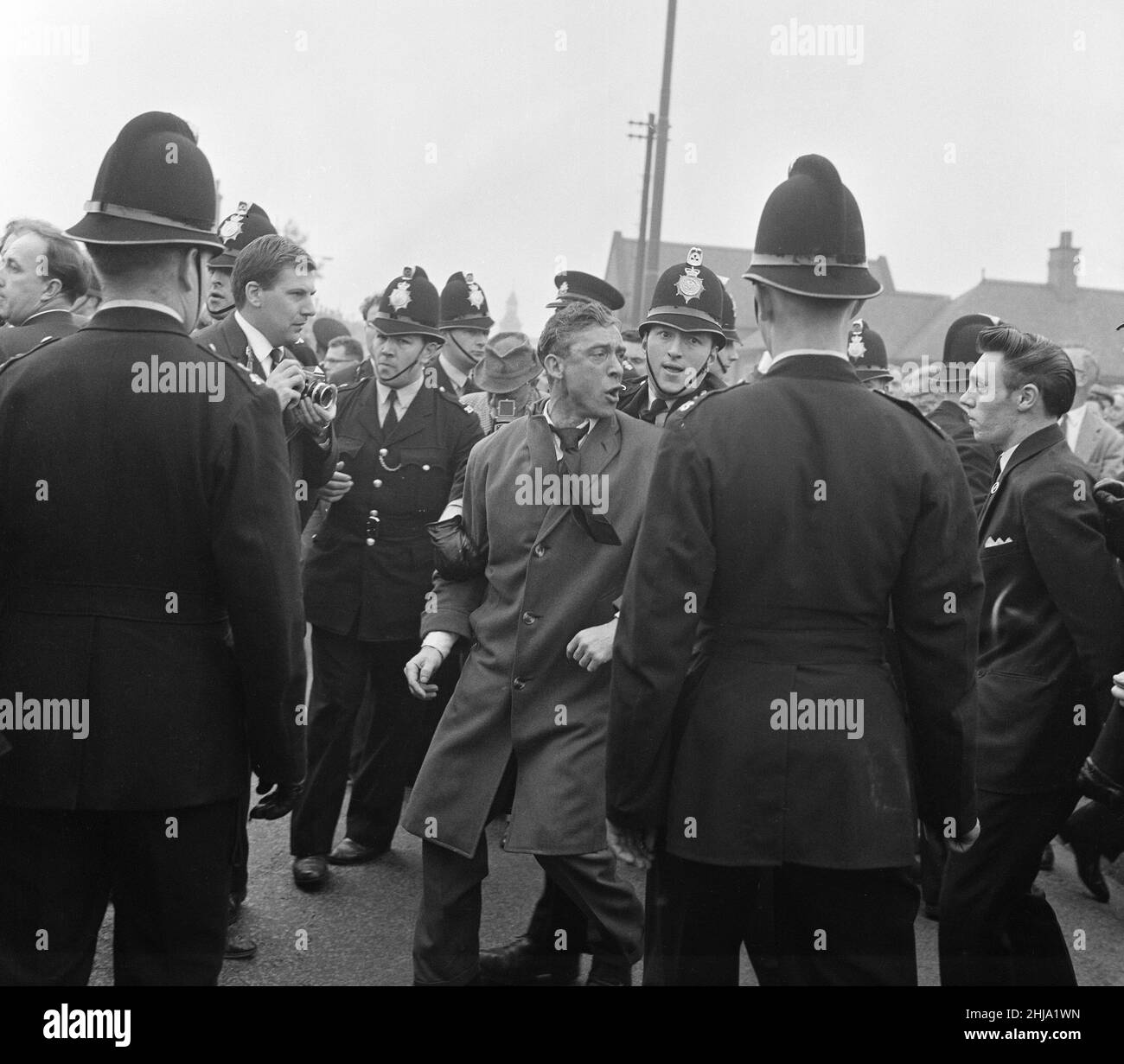 Sir Oswald Mosley se rend à Manchester pour participer à une marche organisée par son Union britannique des partisans des fascistes, dimanche 29th juillet 1962.Quand les quatre-vingt marcheurs se sont rassemblés, une foule en colère les a précipités et Mosley a disparu dans une vague de poings et de bottes volants et ses bannières de groupe ont été déchirées pour les tatouer.La police a brisé la foule des combats et a secouru Mosley, 65 ans, mais la marche s'est rapidement transformée en une émeute causant un mile de terreur avec des combats qui éclatent à quelques mètres.De nombreux marcheurs sont tombés avec des visages qui se saignent et des vêtements déchirés.Les autres ont été pillés avec des pierres, des pièces de monnaie, des choux, des tomates A. Banque D'Images Sir Oswald Mosley se rend à Manchester pour participer à une marche organisée par son Union britannique des partisans des fascistes, dimanche 29th juillet 1962.Quand les quatre-vingt marcheurs se sont rassemblés, une foule en colère les a précipités et Mosley a disparu dans une vague de poings et de bottes volants et ses bannières de groupe ont été déchirées pour les tatouer.La police a brisé la foule des combats et a secouru Mosley, 65 ans, mais la marche s'est rapidement transformée en une émeute causant un mile de terreur avec des combats qui éclatent à quelques mètres.De nombreux marcheurs sont tombés avec des visages qui se saignent et des vêtements déchirés.Les autres ont été pillés avec des pierres, des pièces de monnaie, des choux, des tomates A. Banque D'Images