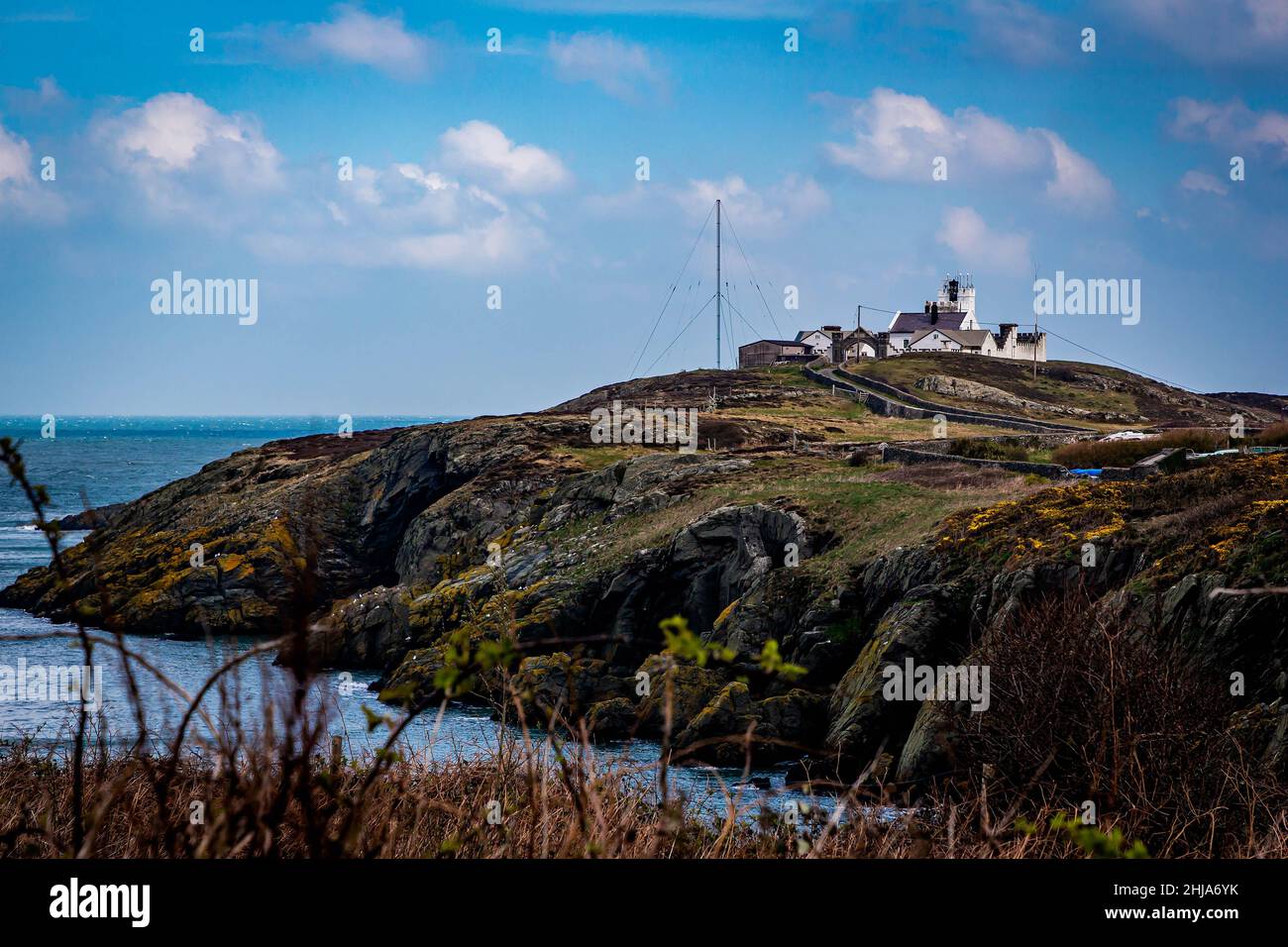 Vue sur le phare de point Lynas et Trwyn Eilian de l'autre côté de la petite baie de Porth Eilian Banque D'Images
