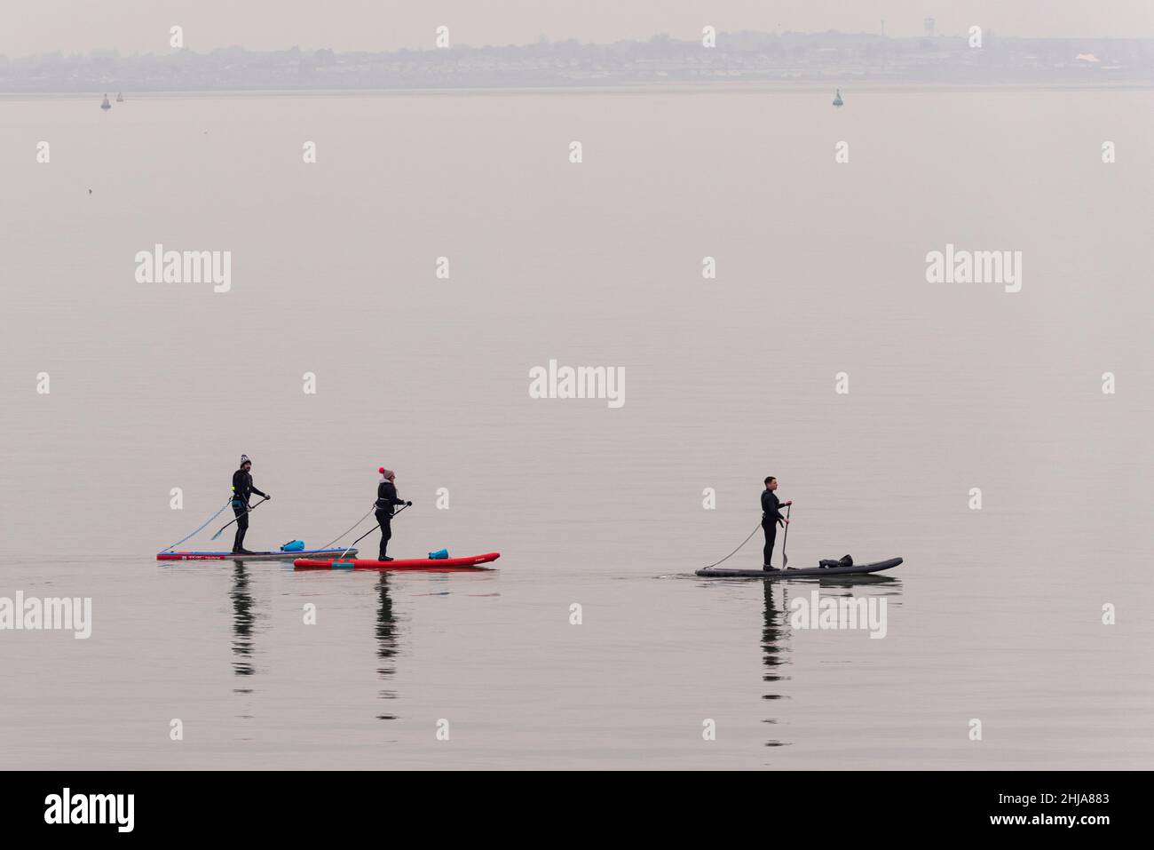 Paddle-board sur l'estuaire de la Tamise tôt sur une mer calme et plate de retour en direction de Chalkwell après avoir passé Southend Pier.Brumeux, calme mort Banque D'Images