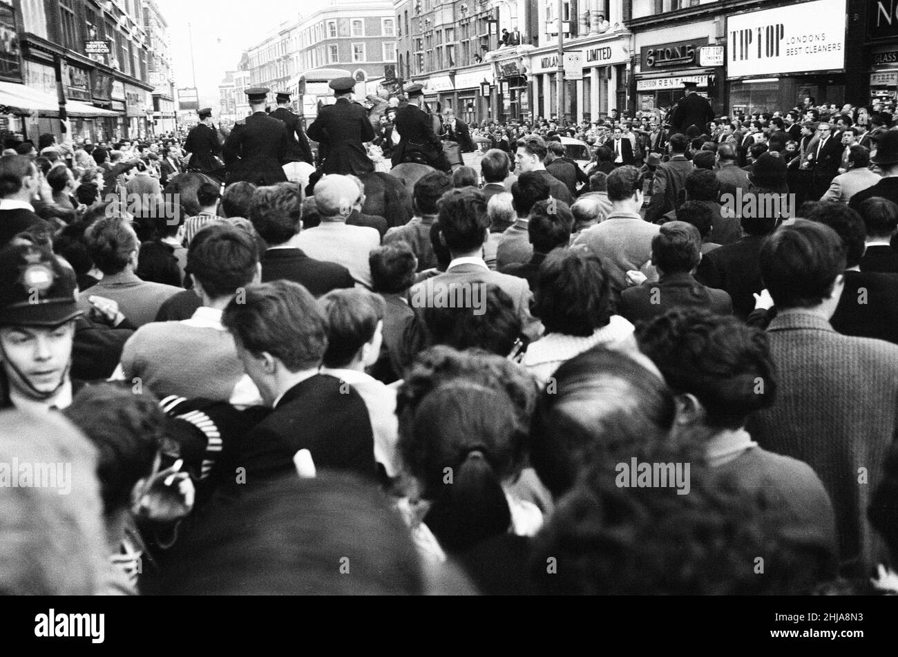 Ridley Road, Londres, mardi 31st juillet 1962.Une foule nombreuse se réunit dans le East End pour perturber un rassemblement de l'ancien dirigeant fasciste Sir Oswald Mosley et des membres de son groupe antisémite Blackshirt qui avait planifié un rassemblement dans le East End de Londres.Mosley et son groupe ont été agressés et poinçonnés au sol dès l'ouverture de sa réunion à Ridley Road, Dalston.La police a clos la réunion dans les trois premières minutes et procédé à 54 arrestations, dont l'une était le fils de Sir Oswald Max. Banque D'Images