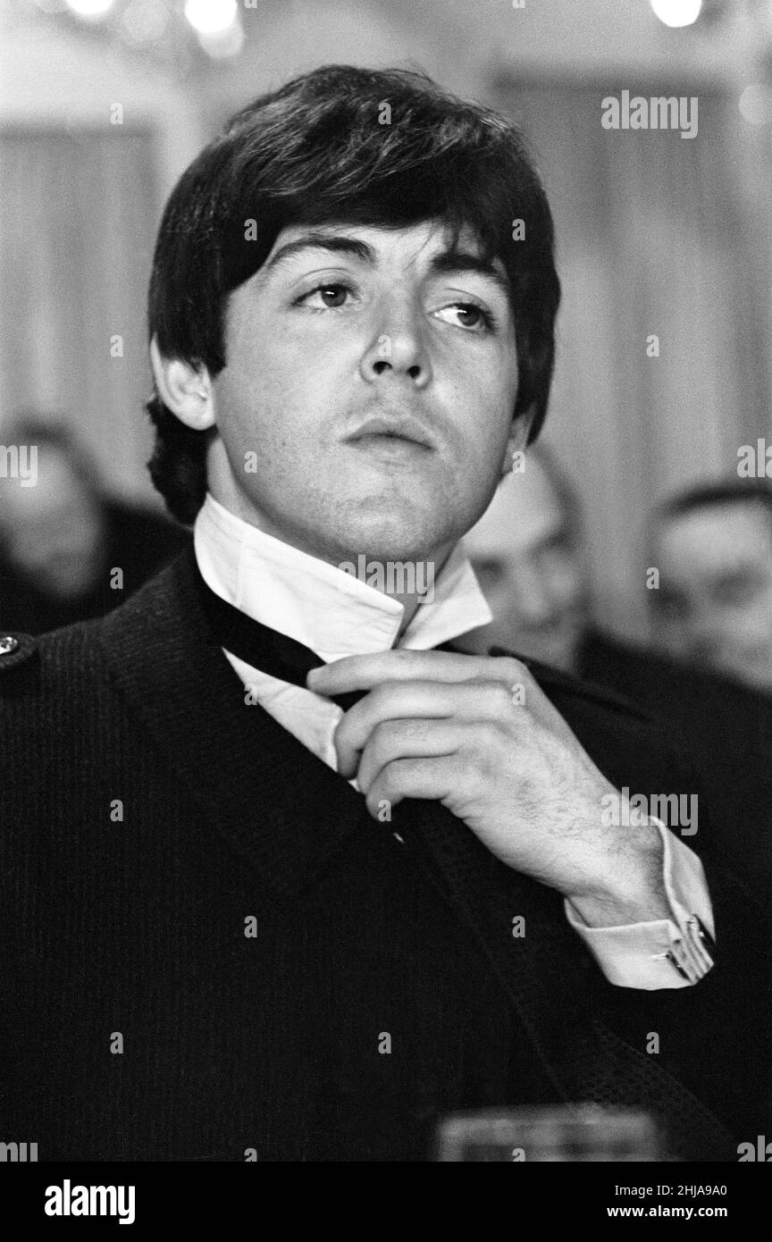 The Beatles, 19th mars 1964. Déjeuner au Club Variety à l'hôtel Dorchester,  Londres, avec le Premier ministre Harold Wilson (spectacles d'images) Paul  McCartney qui joue avec son cravate Photo Stock - Alamy