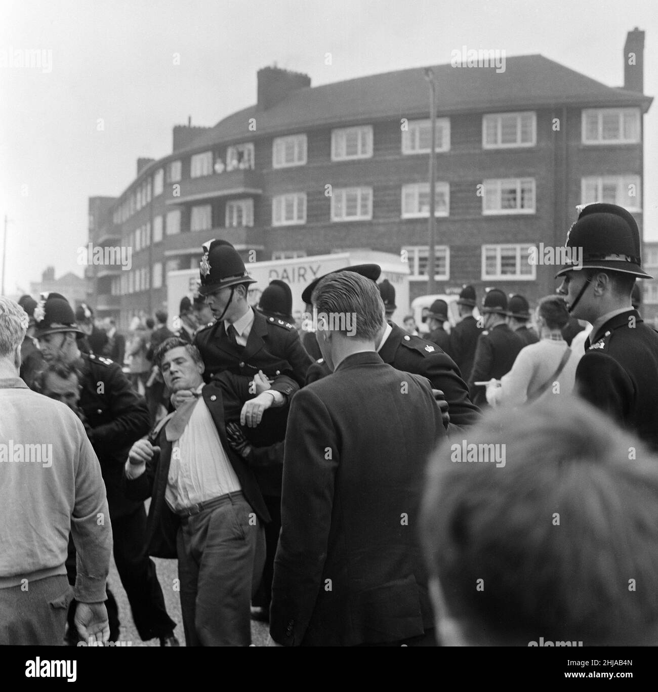 Sir Oswald Mosley se rend à Manchester pour participer à une marche organisée par son Union britannique des partisans des fascistes, dimanche 29th juillet 1962.Quand les quatre-vingt marcheurs se sont rassemblés, une foule en colère les a précipités et Mosley a disparu dans une vague de poings et de bottes volants et ses bannières de groupe ont été déchirées pour les tatouer.La police a brisé la foule des combats et a secouru Mosley, 65 ans, mais la marche s'est rapidement transformée en une émeute causant un mile de terreur avec des combats qui éclatent à quelques mètres.De nombreux marcheurs sont tombés avec des visages qui se saignent et des vêtements déchirés.Les autres ont été pillés avec des pierres, des pièces de monnaie, des choux, des tomates A. Banque D'Images Sir Oswald Mosley se rend à Manchester pour participer à une marche organisée par son Union britannique des partisans des fascistes, dimanche 29th juillet 1962.Quand les quatre-vingt marcheurs se sont rassemblés, une foule en colère les a précipités et Mosley a disparu dans une vague de poings et de bottes volants et ses bannières de groupe ont été déchirées pour les tatouer.La police a brisé la foule des combats et a secouru Mosley, 65 ans, mais la marche s'est rapidement transformée en une émeute causant un mile de terreur avec des combats qui éclatent à quelques mètres.De nombreux marcheurs sont tombés avec des visages qui se saignent et des vêtements déchirés.Les autres ont été pillés avec des pierres, des pièces de monnaie, des choux, des tomates A. Banque D'Images