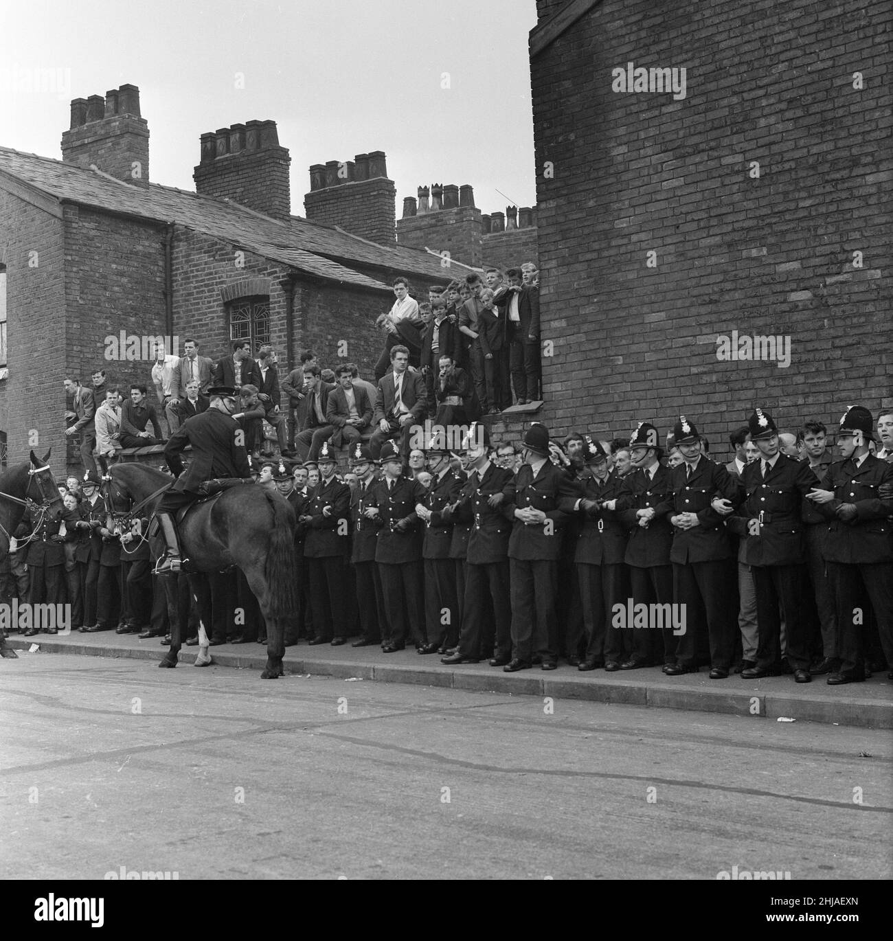 Sir Oswald Mosley se rend à Manchester pour participer à une marche organisée par son Union britannique des partisans des fascistes, dimanche 29th juillet 1962.Quand les quatre-vingt marcheurs se sont rassemblés, une foule en colère les a précipités et Mosley a disparu dans une vague de poings et de bottes volants et ses bannières de groupe ont été déchirées pour les tatouer.La police a brisé la foule des combats et a secouru Mosley, 65 ans, mais la marche s'est rapidement transformée en une émeute causant un mile de terreur avec des combats qui éclatent à quelques mètres.De nombreux marcheurs sont tombés avec des visages qui se saignent et des vêtements déchirés.Les autres ont été pillés avec des pierres, des pièces de monnaie, des choux, des tomates A. Banque D'Images Sir Oswald Mosley se rend à Manchester pour participer à une marche organisée par son Union britannique des partisans des fascistes, dimanche 29th juillet 1962.Quand les quatre-vingt marcheurs se sont rassemblés, une foule en colère les a précipités et Mosley a disparu dans une vague de poings et de bottes volants et ses bannières de groupe ont été déchirées pour les tatouer.La police a brisé la foule des combats et a secouru Mosley, 65 ans, mais la marche s'est rapidement transformée en une émeute causant un mile de terreur avec des combats qui éclatent à quelques mètres.De nombreux marcheurs sont tombés avec des visages qui se saignent et des vêtements déchirés.Les autres ont été pillés avec des pierres, des pièces de monnaie, des choux, des tomates A. Banque D'Images