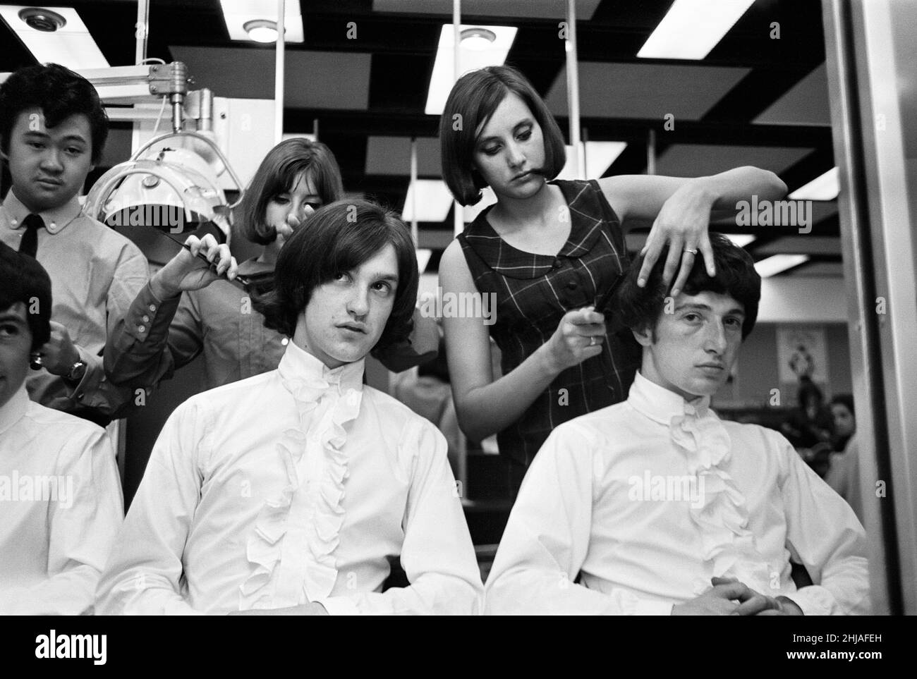 Les membres du groupe pop britannique The Kinks ont leurs cheveux stylisés dans un salon.Dave Davies et Pete Quaife.12th juin 1964. Banque D'Images