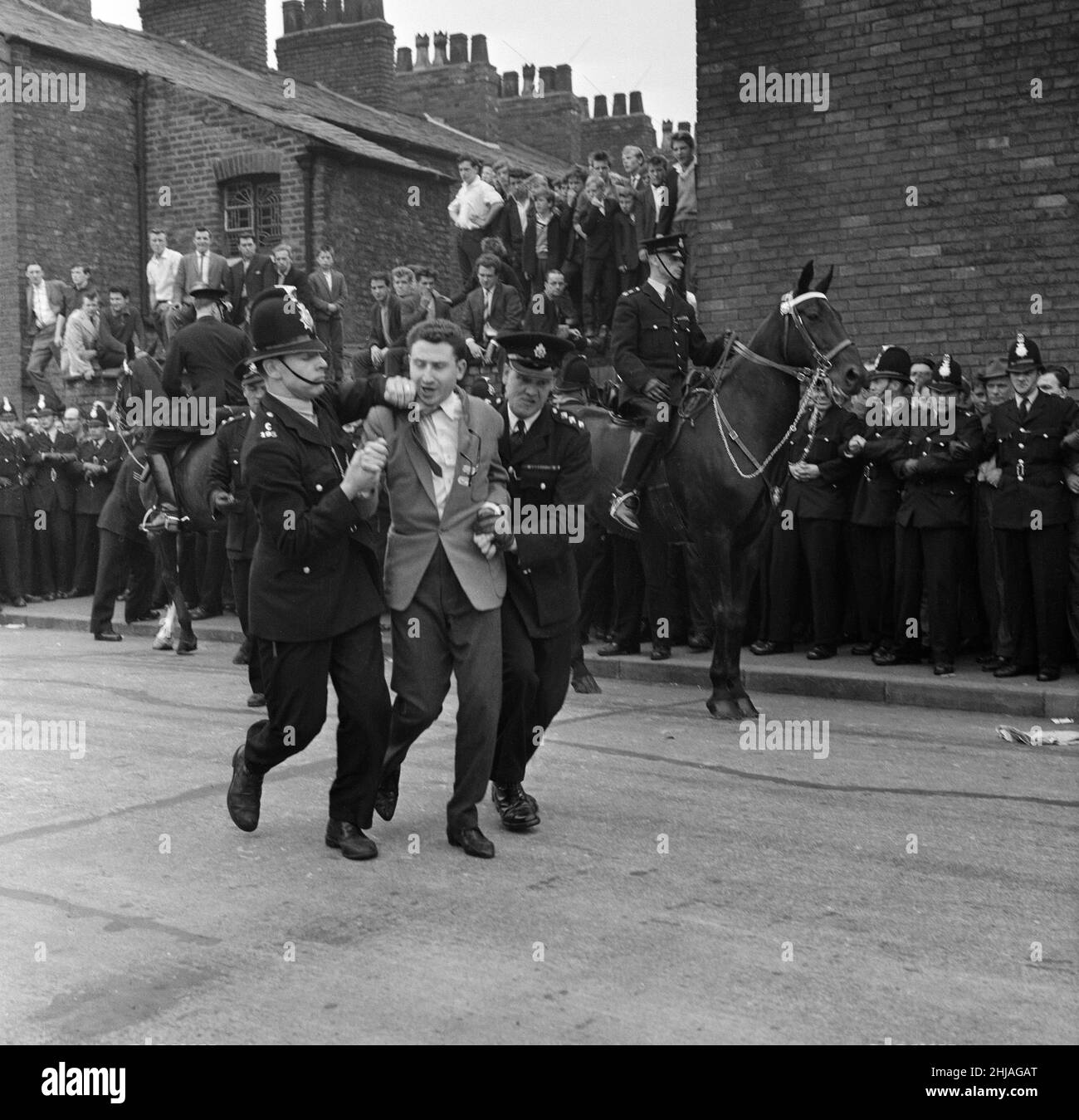 Sir Oswald Mosley se rend à Manchester pour participer à une marche organisée par son Union britannique des partisans des fascistes, dimanche 29th juillet 1962.Quand les quatre-vingt marcheurs se sont rassemblés, une foule en colère les a précipités et Mosley a disparu dans une vague de poings et de bottes volants et ses bannières de groupe ont été déchirées pour les tatouer.La police a brisé la foule des combats et a secouru Mosley, 65 ans, mais la marche s'est rapidement transformée en une émeute causant un mile de terreur avec des combats qui éclatent à quelques mètres.De nombreux marcheurs sont tombés avec des visages qui se saignent et des vêtements déchirés.Les autres ont été pillés avec des pierres, des pièces de monnaie, des choux, des tomates A. Banque D'Images Sir Oswald Mosley se rend à Manchester pour participer à une marche organisée par son Union britannique des partisans des fascistes, dimanche 29th juillet 1962.Quand les quatre-vingt marcheurs se sont rassemblés, une foule en colère les a précipités et Mosley a disparu dans une vague de poings et de bottes volants et ses bannières de groupe ont été déchirées pour les tatouer.La police a brisé la foule des combats et a secouru Mosley, 65 ans, mais la marche s'est rapidement transformée en une émeute causant un mile de terreur avec des combats qui éclatent à quelques mètres.De nombreux marcheurs sont tombés avec des visages qui se saignent et des vêtements déchirés.Les autres ont été pillés avec des pierres, des pièces de monnaie, des choux, des tomates A. Banque D'Images