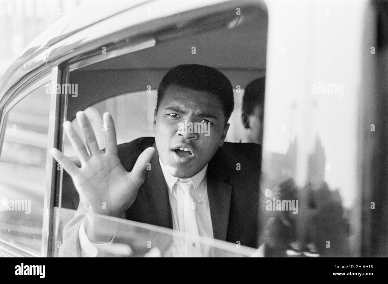 Cassius Clay aka (Muhammad Ali) fait des vagues de sa voiture après son arrivée à Londres.il est en Grande-Bretagne pour une lutte sans titre contre Henry Cooper à Wembley le 18th juin.27th mai 1963. Banque D'Images