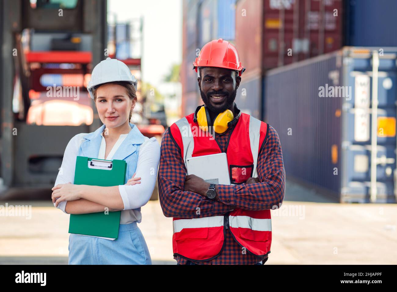 Contremaître et travailleur en confiance et avec succès. Personnes travaillant sur le lieu de travail d'un entrepôt de conteneurs industriels. Banque D'Images