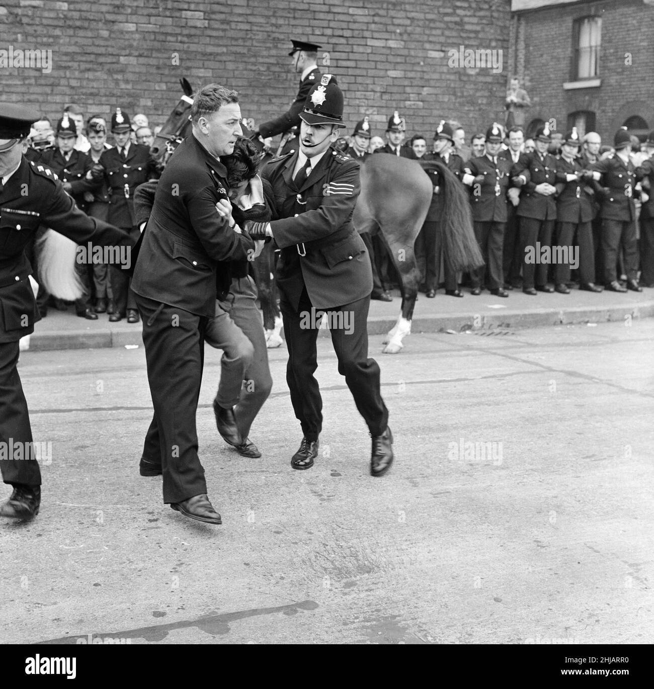 Sir Oswald Mosley se rend à Manchester pour participer à une marche organisée par son Union britannique des partisans des fascistes, dimanche 29th juillet 1962.Quand les quatre-vingt marcheurs se sont rassemblés, une foule en colère les a précipités et Mosley a disparu dans une vague de poings et de bottes volants et ses bannières de groupe ont été déchirées pour les tatouer.La police a brisé la foule des combats et a secouru Mosley, 65 ans, mais la marche s'est rapidement transformée en une émeute causant un mile de terreur avec des combats qui éclatent à quelques mètres.De nombreux marcheurs sont tombés avec des visages qui se saignent et des vêtements déchirés.Les autres ont été pillés avec des pierres, des pièces de monnaie, des choux, des tomates A. Banque D'Images Sir Oswald Mosley se rend à Manchester pour participer à une marche organisée par son Union britannique des partisans des fascistes, dimanche 29th juillet 1962.Quand les quatre-vingt marcheurs se sont rassemblés, une foule en colère les a précipités et Mosley a disparu dans une vague de poings et de bottes volants et ses bannières de groupe ont été déchirées pour les tatouer.La police a brisé la foule des combats et a secouru Mosley, 65 ans, mais la marche s'est rapidement transformée en une émeute causant un mile de terreur avec des combats qui éclatent à quelques mètres.De nombreux marcheurs sont tombés avec des visages qui se saignent et des vêtements déchirés.Les autres ont été pillés avec des pierres, des pièces de monnaie, des choux, des tomates A. Banque D'Images